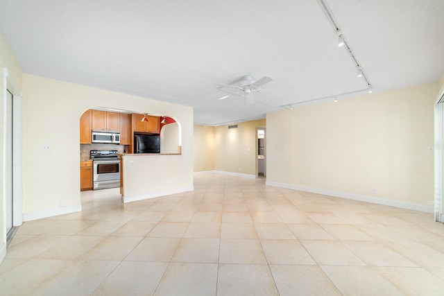 unfurnished living room with rail lighting, light tile patterned flooring, and ceiling fan