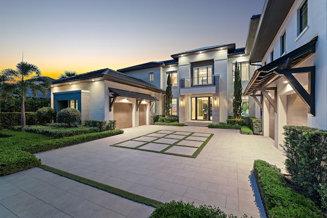 view of front of house featuring a garage and a balcony