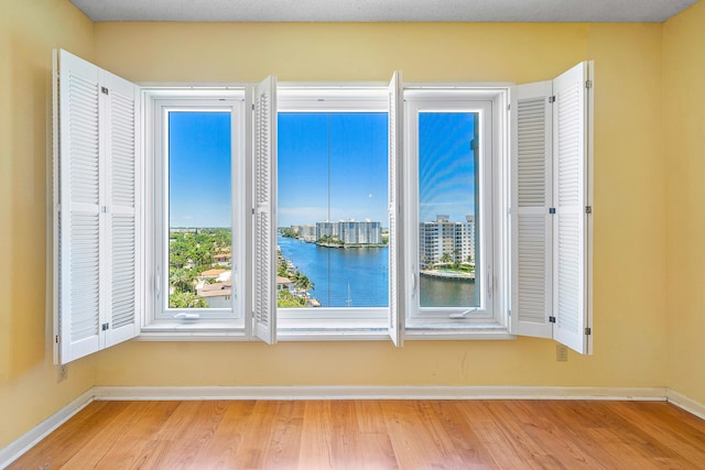 room details with hardwood / wood-style flooring and a water view