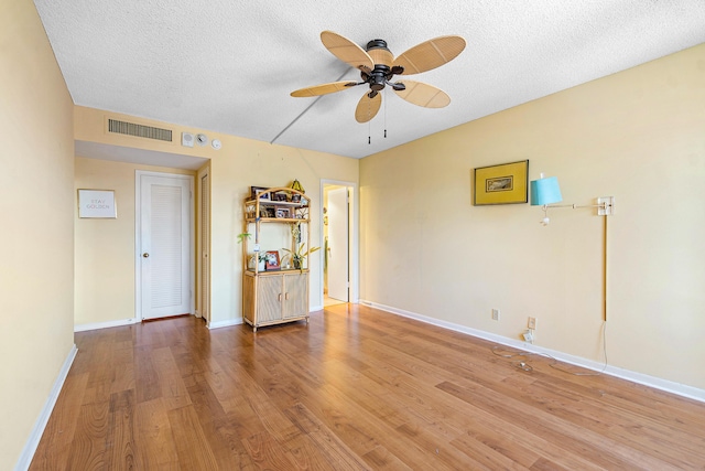 spare room featuring ceiling fan, a textured ceiling, and light hardwood / wood-style flooring