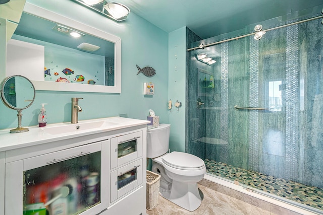 bathroom with tile patterned flooring, vanity, a shower with shower door, and toilet