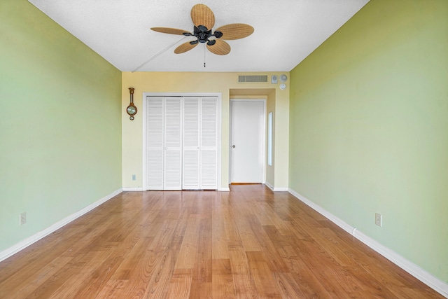 unfurnished bedroom featuring ceiling fan, light hardwood / wood-style flooring, and a closet