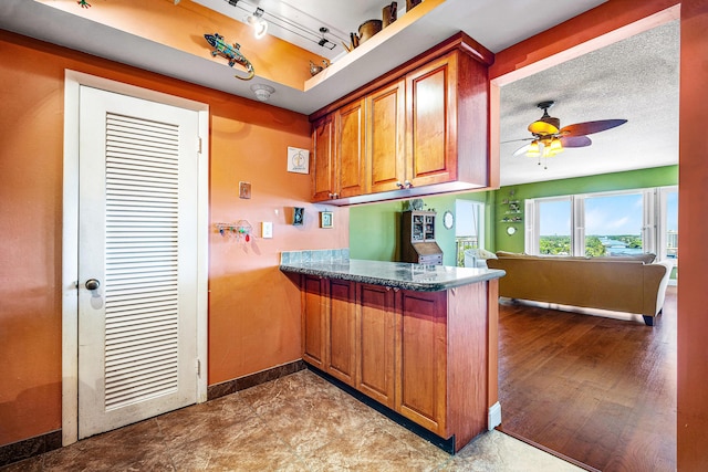 kitchen with ceiling fan, kitchen peninsula, and a textured ceiling