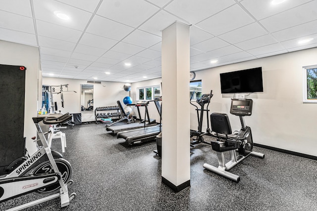 gym with a drop ceiling and a healthy amount of sunlight