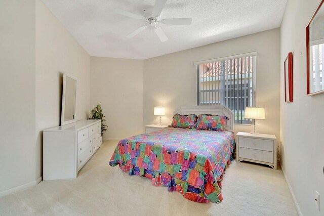 bedroom with light carpet, a textured ceiling, and ceiling fan