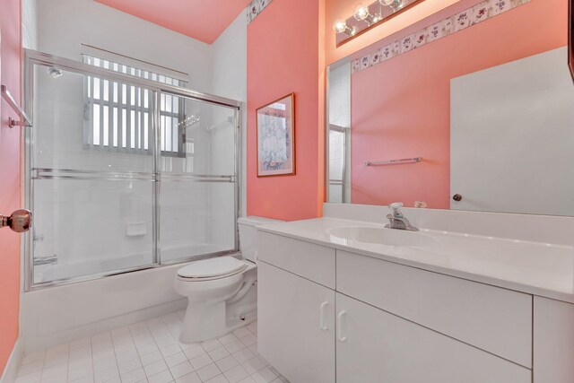 full bathroom with enclosed tub / shower combo, vanity, tile patterned floors, and toilet