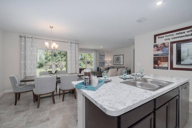 kitchen with hanging light fixtures, dishwasher, an inviting chandelier, a center island with sink, and sink