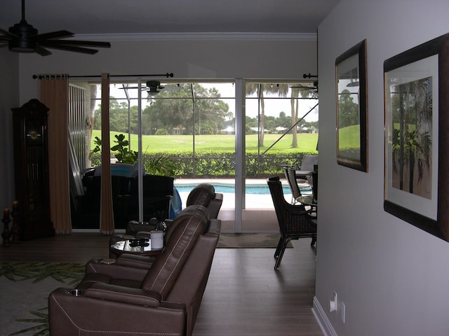 living room featuring hardwood / wood-style floors, ceiling fan, and crown molding