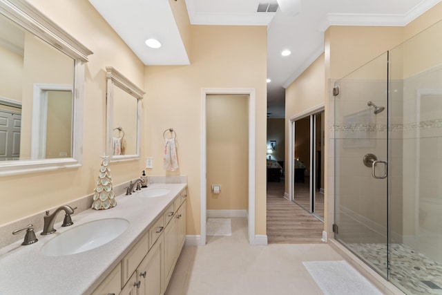 bathroom featuring walk in shower, ornamental molding, and vanity