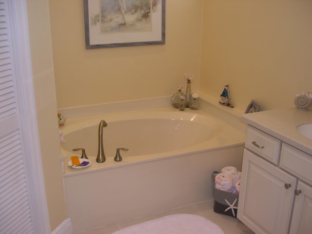 bathroom with tile patterned flooring, a washtub, and vanity