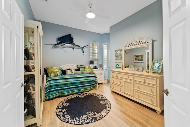 bedroom with a ceiling fan, visible vents, and light wood finished floors