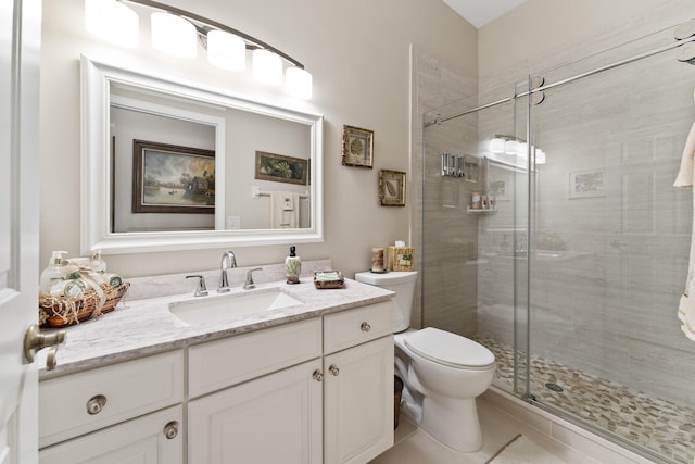 bathroom featuring vanity, toilet, tile patterned flooring, and a shower with door