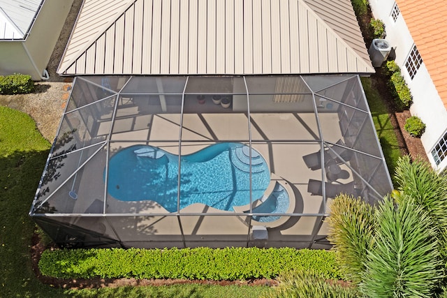 view of swimming pool featuring glass enclosure