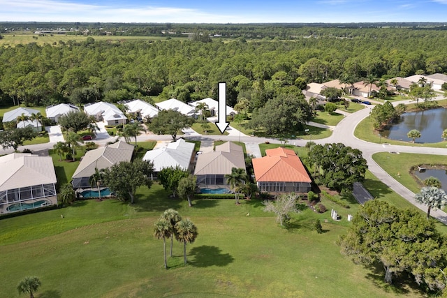 drone / aerial view with a residential view, a forest view, and a water view