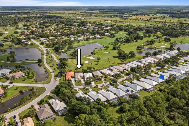 drone / aerial view with a residential view, golf course view, and a water view