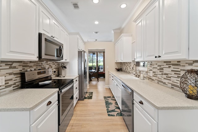 kitchen with decorative backsplash, stainless steel appliances, visible vents, and a sink