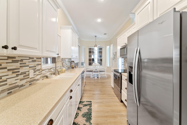 kitchen with light wood-type flooring, backsplash, sink, appliances with stainless steel finishes, and white cabinets