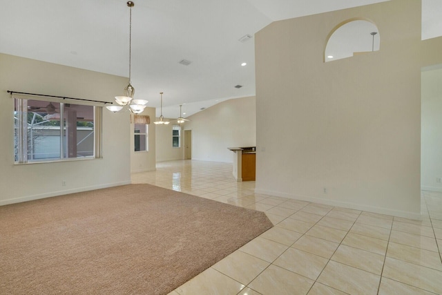 tiled spare room with lofted ceiling and a notable chandelier