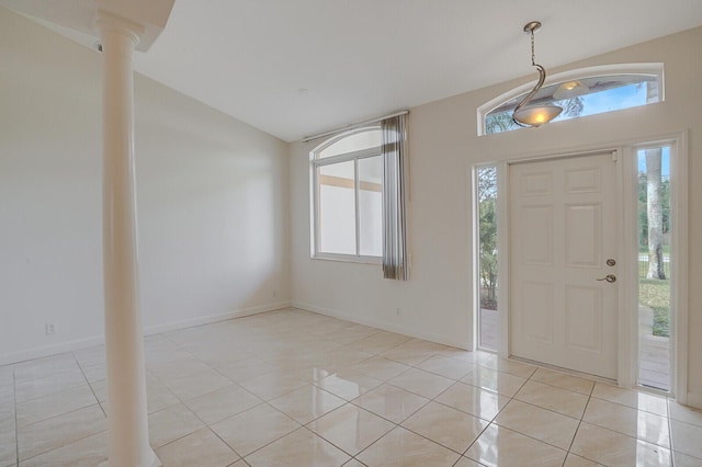 tiled entryway featuring lofted ceiling and decorative columns