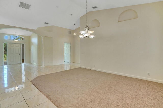 tiled spare room with a chandelier and high vaulted ceiling