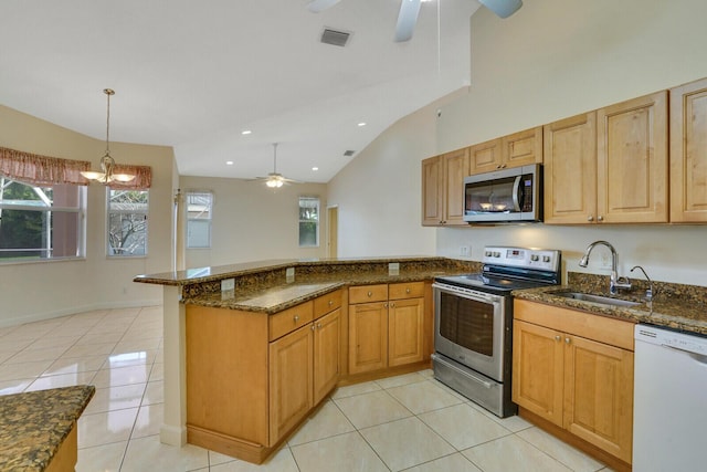 kitchen with pendant lighting, sink, appliances with stainless steel finishes, kitchen peninsula, and dark stone counters