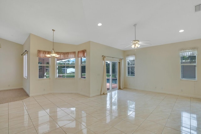 tiled empty room featuring vaulted ceiling and ceiling fan with notable chandelier