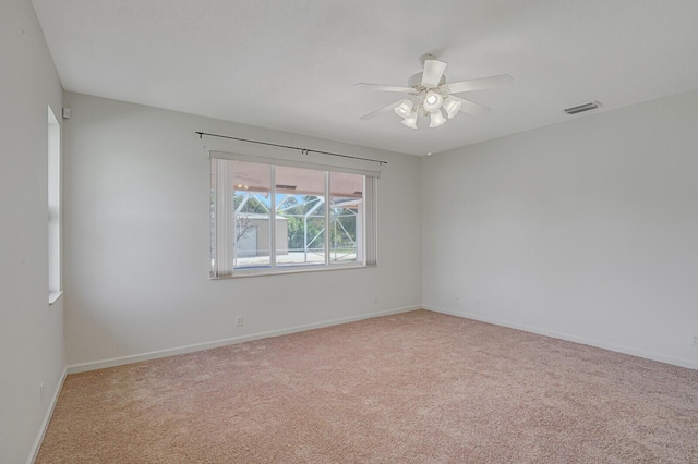 unfurnished room with light colored carpet and ceiling fan