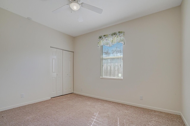 spare room featuring light carpet and ceiling fan