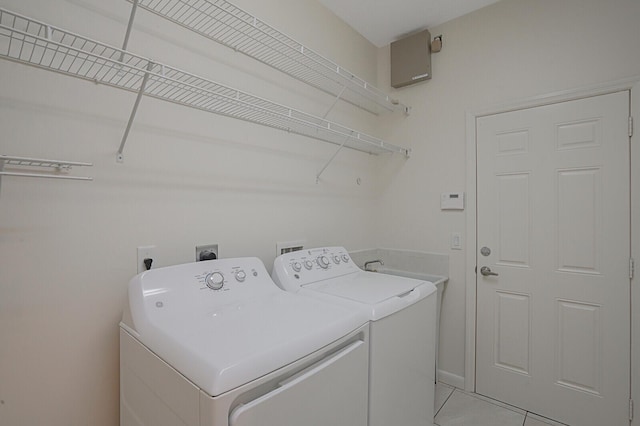 clothes washing area featuring washer and dryer and light tile patterned floors