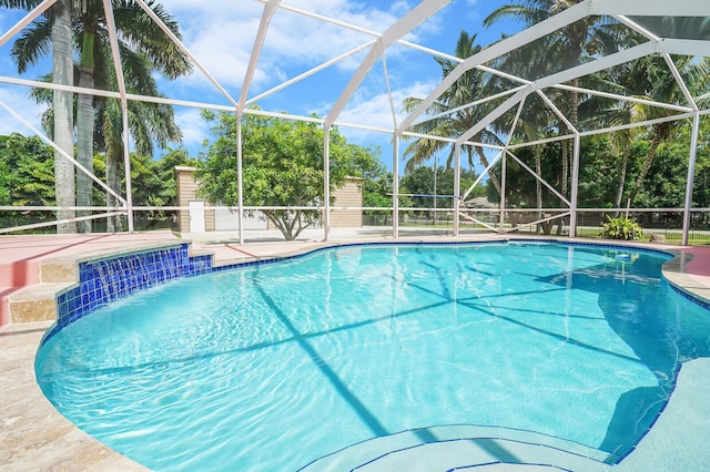 view of swimming pool featuring a patio area, pool water feature, and glass enclosure