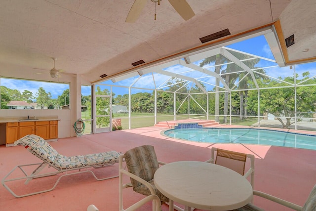 view of swimming pool with a lanai, exterior kitchen, sink, and a patio