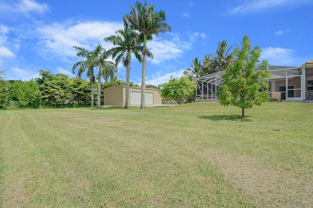 view of yard with a garage, an outdoor structure, and glass enclosure