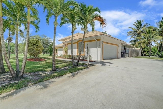 mediterranean / spanish house with a garage and a front yard