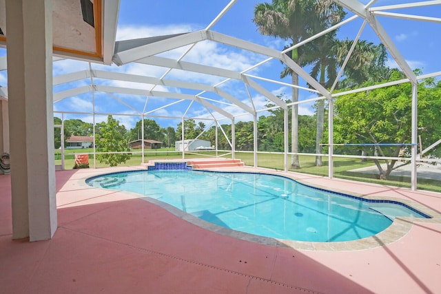 view of pool featuring a lawn, a patio, and glass enclosure