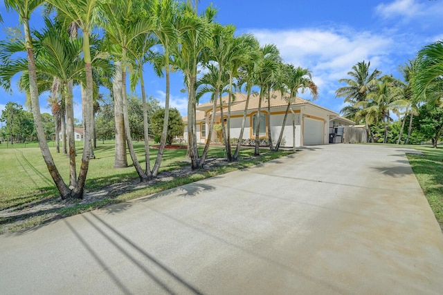 view of front of property with a garage and a front lawn