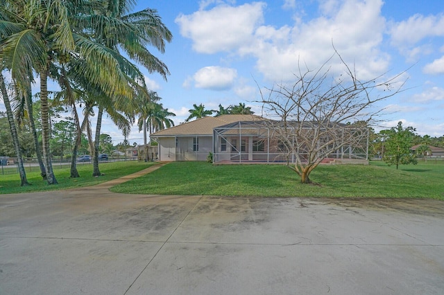 view of front of property with a front yard and glass enclosure