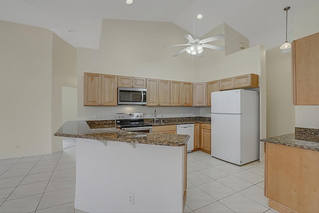 kitchen featuring stainless steel appliances, kitchen peninsula, light tile patterned floors, and dark stone counters