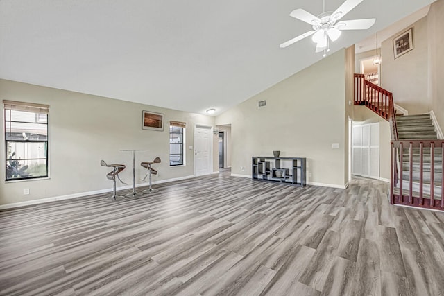 unfurnished living room featuring ceiling fan, high vaulted ceiling, and light hardwood / wood-style floors