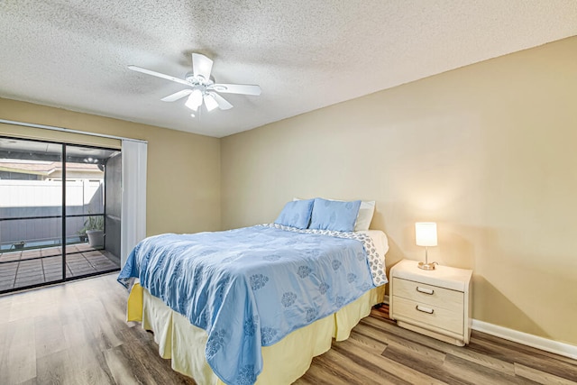 bedroom featuring ceiling fan, access to exterior, a textured ceiling, and wood-type flooring