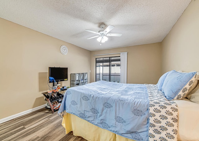 bedroom featuring a textured ceiling, ceiling fan, and wood-type flooring