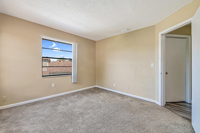 carpeted spare room with a textured ceiling