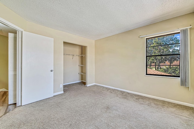 unfurnished bedroom featuring a textured ceiling, a closet, and carpet