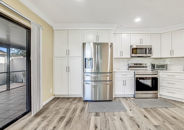 kitchen featuring tasteful backsplash, white cabinetry, light wood-type flooring, ornamental molding, and stainless steel appliances