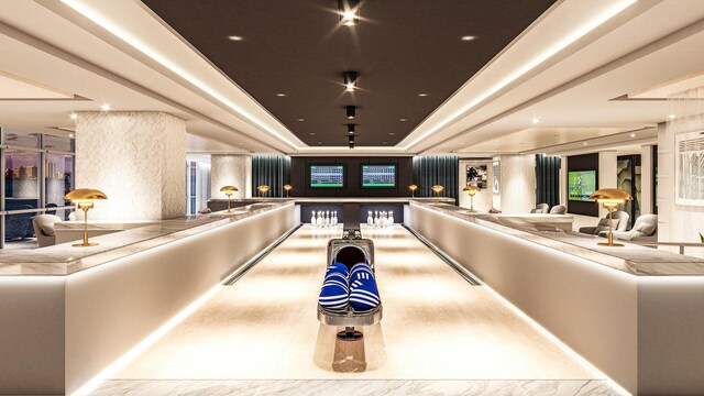 game room with a raised ceiling and a bowling alley