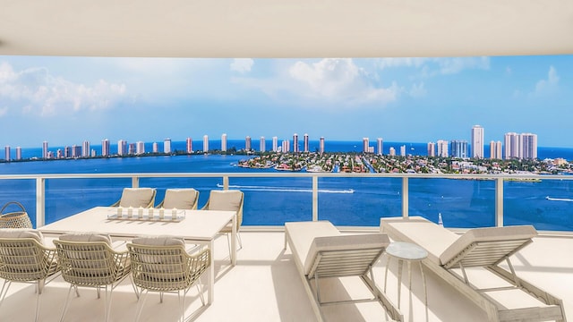 view of patio / terrace with a view of city, a balcony, and a water view