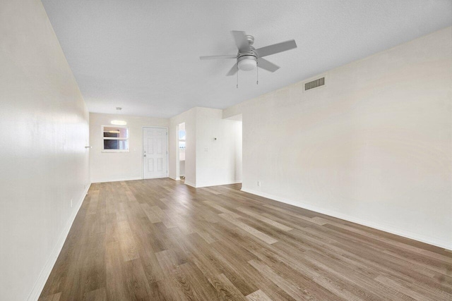 unfurnished living room featuring ceiling fan and hardwood / wood-style floors