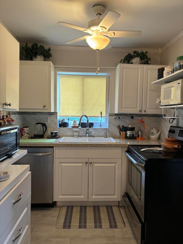 kitchen with decorative backsplash, white cabinets, stainless steel appliances, and ceiling fan