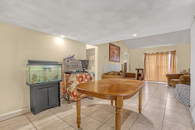 dining space with lofted ceiling and tile patterned flooring