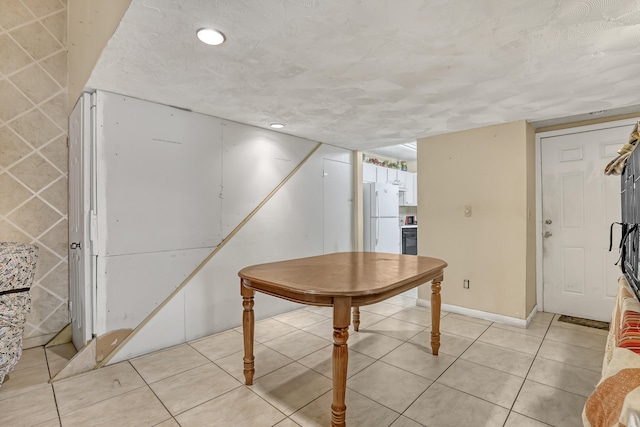 dining room featuring light tile patterned floors and a textured ceiling