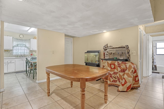 dining space featuring sink and light tile patterned floors